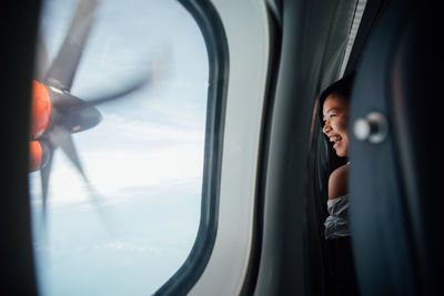 Young woman using mobile phone in airplane