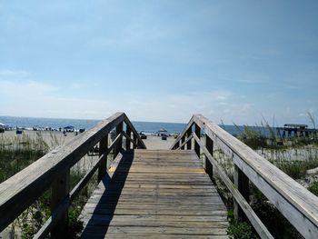 Wooden pier over sea against sky