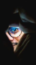 Close-up portrait of man in darkroom