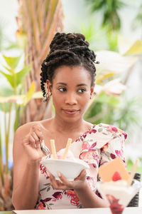 Portrait of a smiling young woman holding ice cream