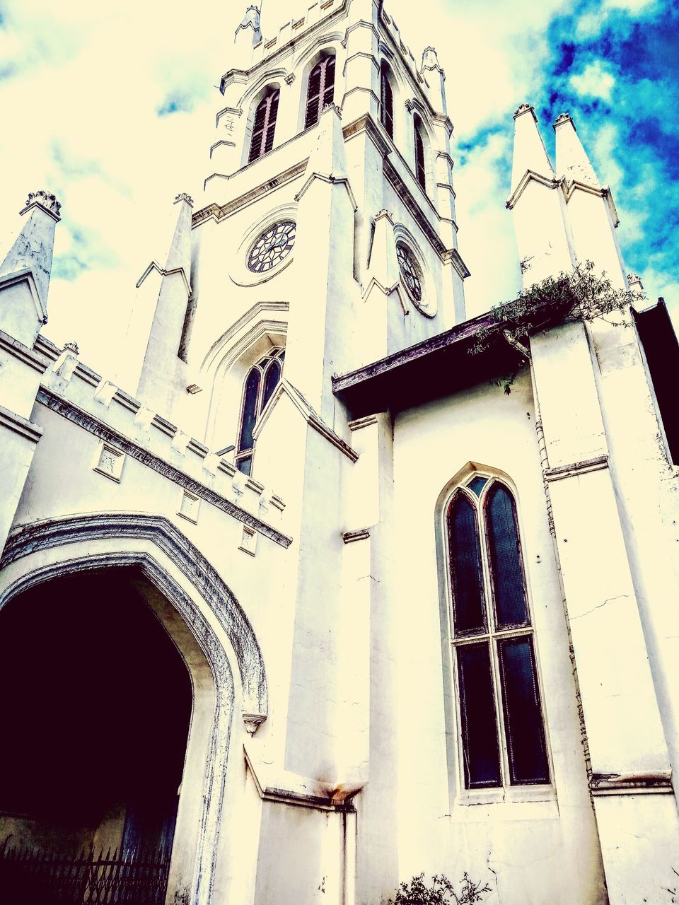 low angle view, architecture, building exterior, built structure, cloud - sky, religion, place of worship, outdoors, spirituality, sky, day, window, history, arch, no people, facade