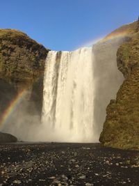 Scenic view of waterfall against sky