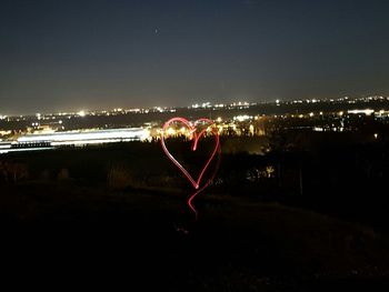 Heart shape illuminated against sky at night