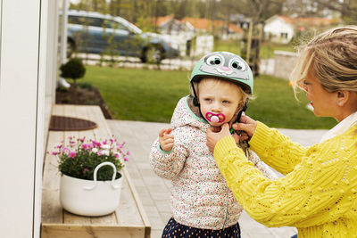 Mother putting his daughters bicycle helmet on for her