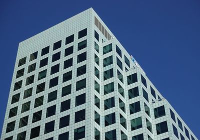 Low angle view of office building against clear blue sky