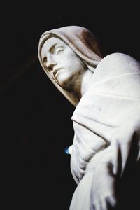 Low angle view of man statue against black background