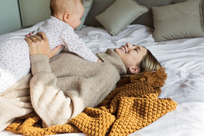 Low angle view of baby relaxing on bed at home