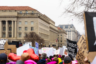 People on street amidst buildings in city