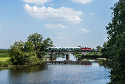 Arch bridge over river against sky