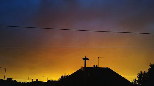 Low angle view of silhouette buildings against sky