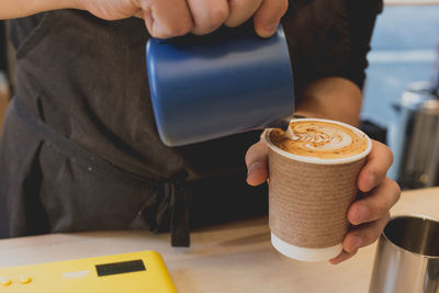 Midsection of person holding coffee cup