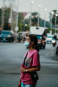 Woman standing on road in city