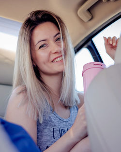 Portrait of young woman sitting in car