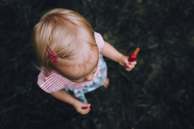 High angle view of baby girl holding flavored ice cream