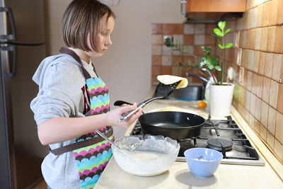 Midsection of woman having food at home