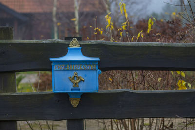 Close-up of metal railing against trees