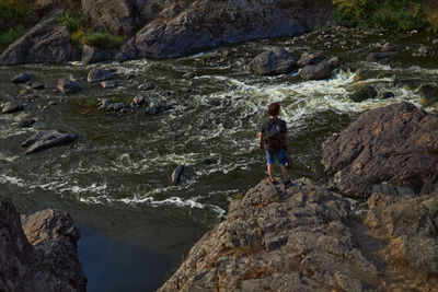 Rear view of man standing on rock