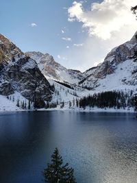 Scenic view of lake by mountains against sky during winter