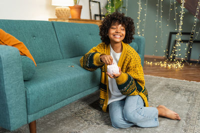 Young woman sitting on sofa at home