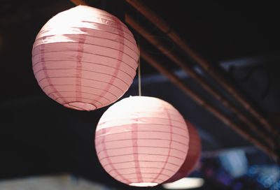 Low angle view of illuminated lanterns hanging at night