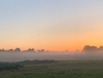 Scenic view of field against sky during sunset