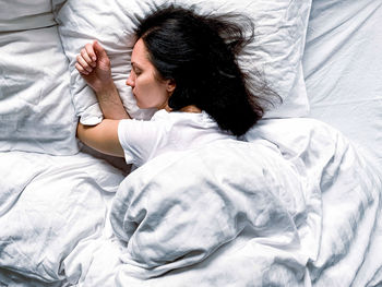 Young woman sleeping on bed at home