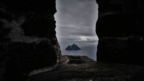 Rock formations by sea against buildings