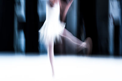 Blurred motion of female dancer dancing in room