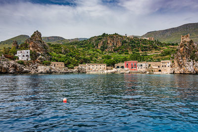 Scenic view of sea against cloudy sky in scopello