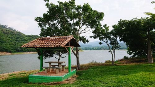 Gazebo by lake against sky