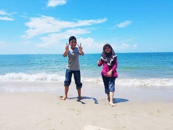 Full length of children on beach against sky