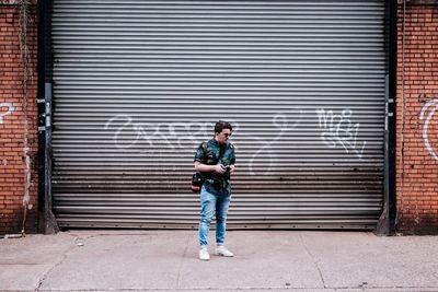 Full length of man standing against shutter