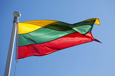 Low angle view of flag against clear blue sky