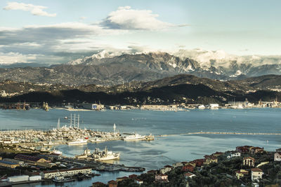 High angle view of city by sea against sky