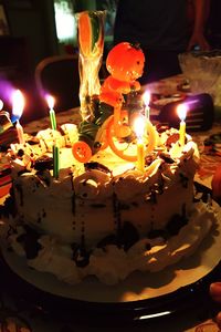 Close-up of lit candle in dark room