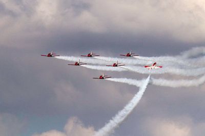 Low angle view of fighter planes flying against sky