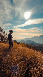 Man standing on field against sky