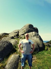 Man standing by rock against sky