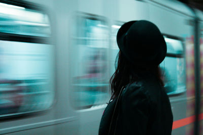 Rear view of woman standing by train