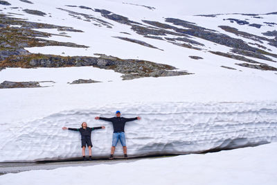 Man and woman along a snowdrift in the snow covered mountains in norway 
