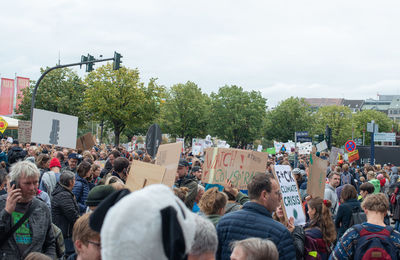 People on street in city against sky