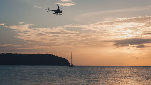 Boat sailing in sea at sunset