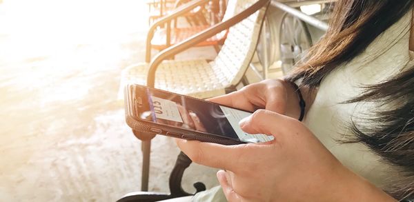 Midsection of woman using mobile phone