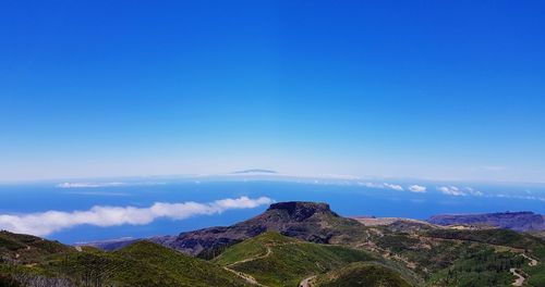 Scenic view of mountains against blue sky