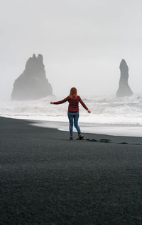 Lady enjoying view of rocks on black iceland beach scenic photography