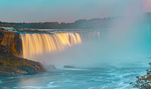 Scenic view of waterfall against sky