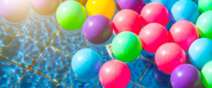 High angle view of multi colored balls in water