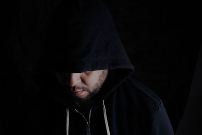 Portrait of man wearing hat against black background