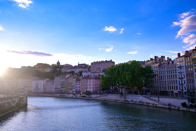 Bridge over river against buildings in city