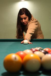 Brunette caucasian girl plays billiards